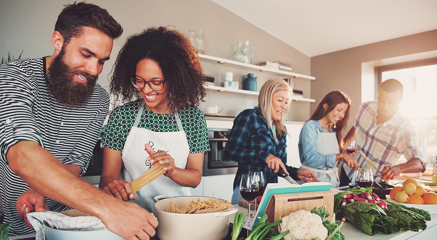 Family preparing dinner while drinking wine