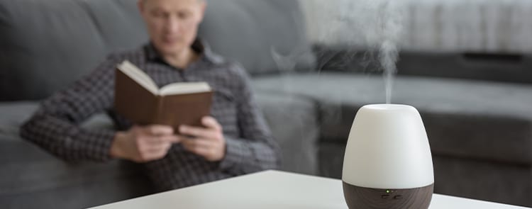 man reading in the background while using an air freshener