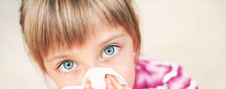 little girl blowing her nose